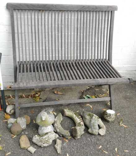 A teak folding garden bench, with slatted seat and back, together with various garden ornaments...