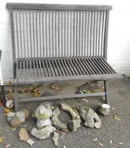 A teak folding garden bench, with slatted seat and back, together with various garden ornaments...