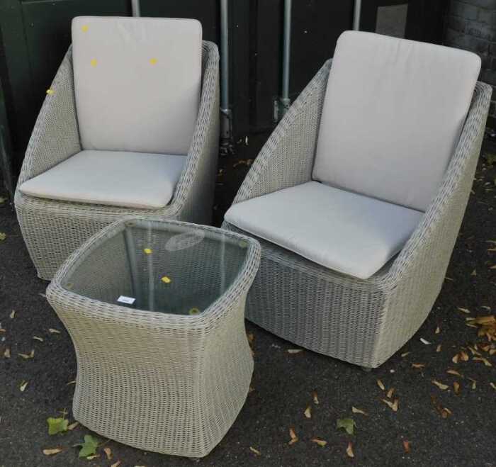 Two wicker garden chairs, with loose seat cushions, together with a matching hourglass shaped...