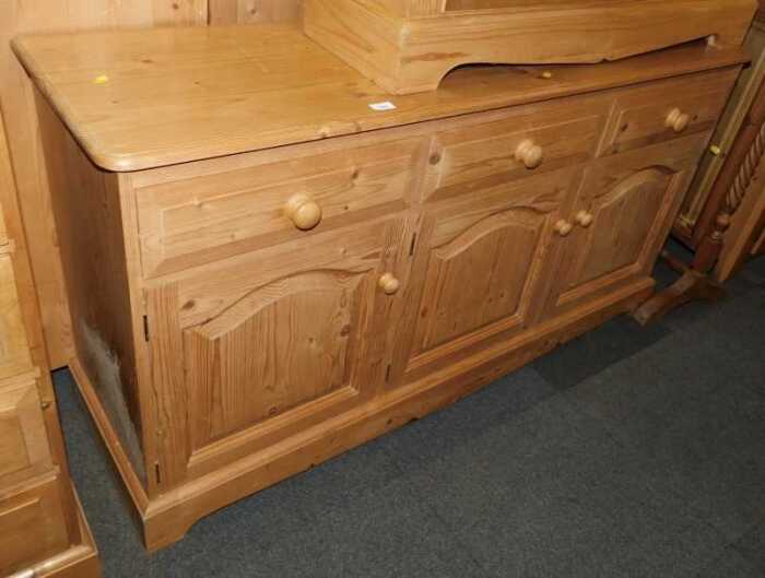 A pine sideboard, with three drawers above three panelled cupboards, raised on bracket feet,...