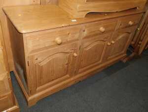 A pine sideboard, with three drawers above three panelled cupboards, raised on bracket feet,...