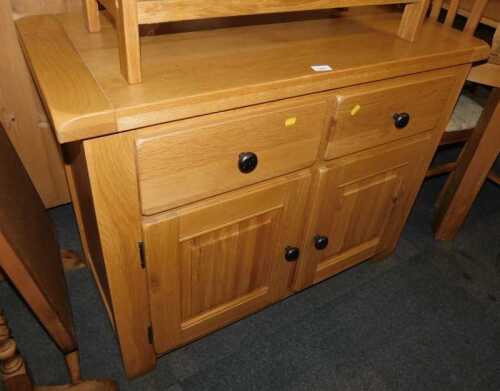 A contemporary oak sideboard, with two drawers above two panelled cupboards, raised on stiles,...
