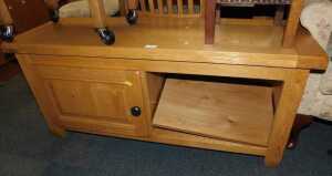 A contemporary oak television unit, the rectangular top above a panelled cupboard door flanked...