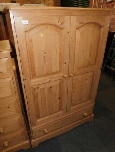 A contemporary pine child's wardrobe, the double panelled doors enclosing a single hanging rail,...