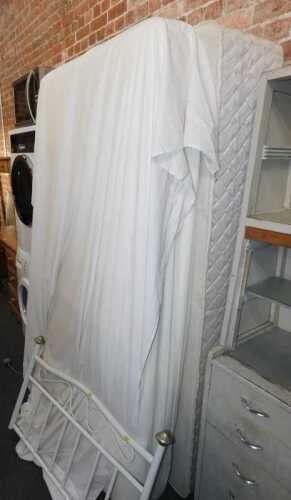 A single bed, comprising metal headboard, mattress and divan bed base.