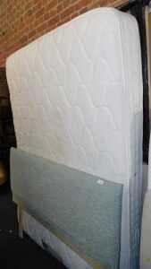 A double bed, comprising upholstered headboard, mattress and bed base.