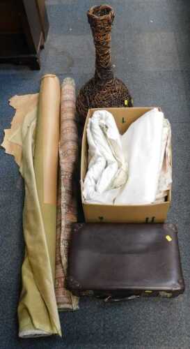 Upholstery and curtain material, a wicker vase, and a brown leather suitcase.