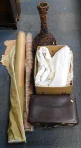Upholstery and curtain material, a wicker vase, and a brown leather suitcase.