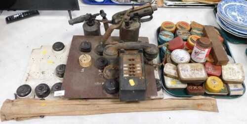 Two framed displays of Bakelite light switches, together with two brass blowtorches, an oil can,...