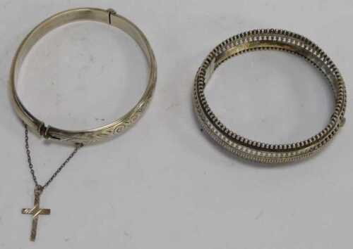 A silver bangle, with engine engraved scrolling decoration, together with a white metal filigree...
