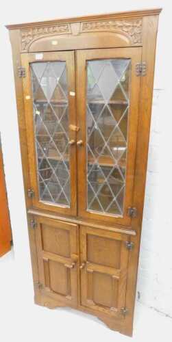 A carved oak freestanding corner display cabinet.