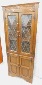 A carved oak freestanding corner display cabinet.