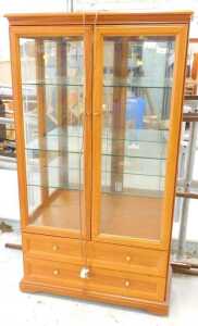 A teak display cabinet, with two doors revealing adjustable glazed shelves, above two long...