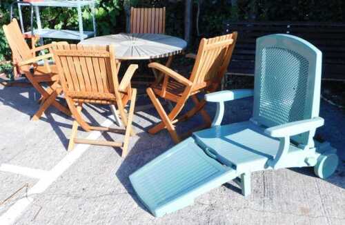 A teak harlequin patio suite, comprising table and folding chairs, with further folding recliner.