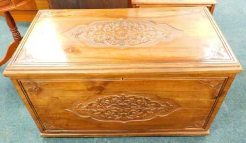 A 20thC camphorwood chest, of rectangular form, heavily carved with a candle box interior, with...