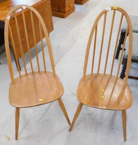 Two Ercol elm quaker design dining chairs, with shaped seat on turned legs. (2)