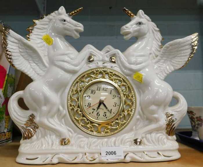 An elaborate 20thC quartz mantel clock, with pottery unicorn surround.