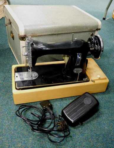 A Champion sewing machine, on teak style base, in fitted case.