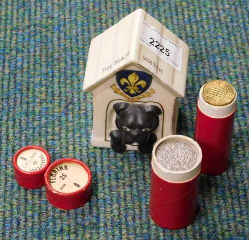 A Shelley crested Black Watch dog in kennel and various low denomination coins, two shillings etc.