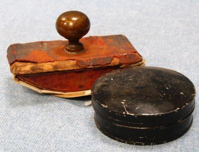 *A circular metal stamp pad and a leather and turned handled ink blotter.