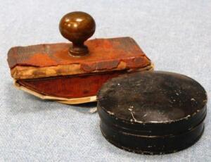 *A circular metal stamp pad and a leather and turned handled ink blotter.