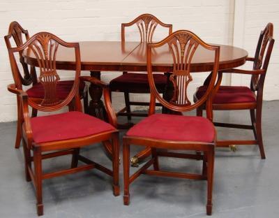 *A reproduction Regency twin pillar extending dining table and a set of six Sheraton designed dining