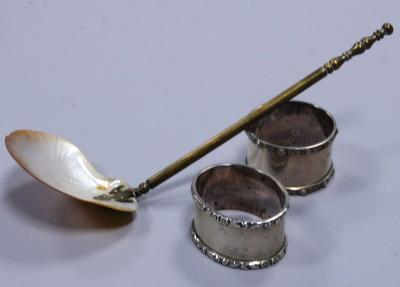 Two silver napkin rings and a shell spoon.