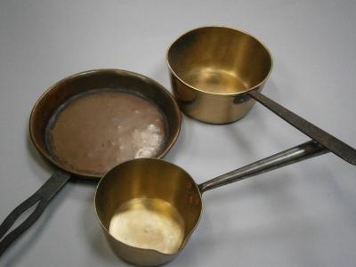 Two brass saucepans and a copper frying pan.