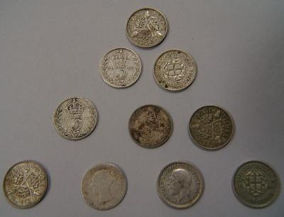 A collection of crowns and threepenny pieces with other mixed coins.