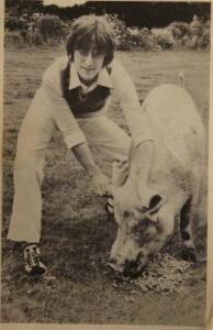 A postcard picture of John Lennon with a pig.