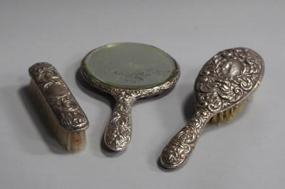 A silver backed three piece dressing table set