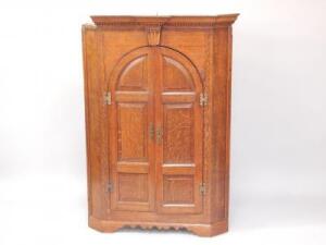 A George III oak hanging corner cupboard
