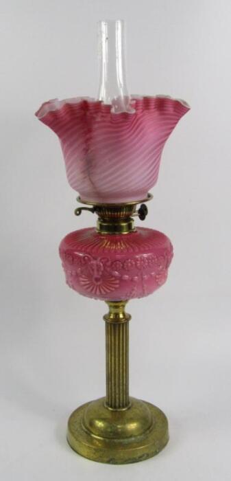 A Victorian brass oil lamp with a pink opaline glass reservoir