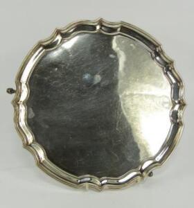 A silver circular pie crust salver