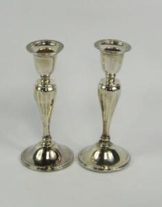 A pair of George V silver loaded candlesticks