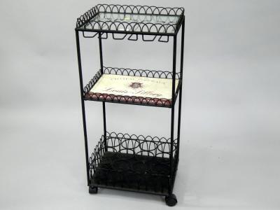A wrought iron and glass advertising wine stand