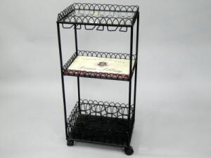 A wrought iron and glass advertising wine stand