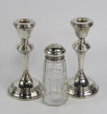 A pair of loaded silver candlesticks