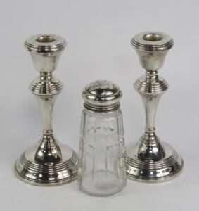 A pair of loaded silver candlesticks
