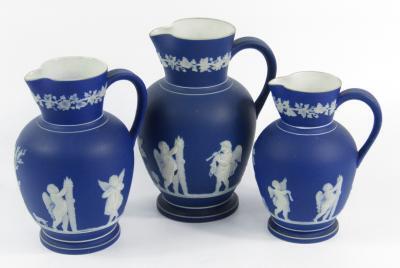 A graduated set of three blue Jasperware jugs