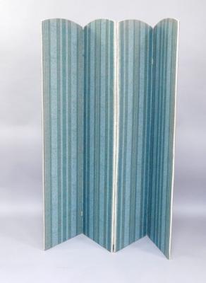 A patterned blue fabric covered four fold screen