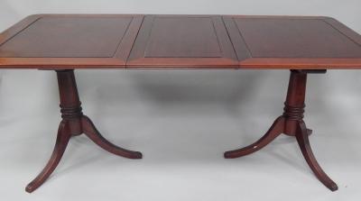 A reproduction mahogany twin pedestal extending dining table