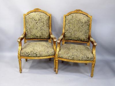A pair of French style gilt gesso open armchairs