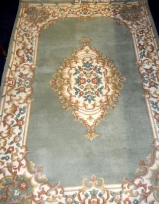 A Chinese floral green ground rug