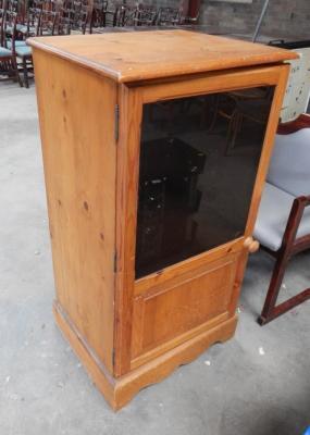 A pine glazed single door cabinet.