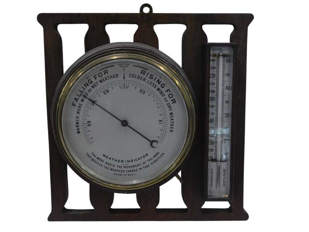 An aneroid barometer and thermometer, both mounted into an oak case ...