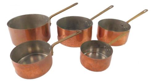 A set of five French copper and brass graduated saucepans