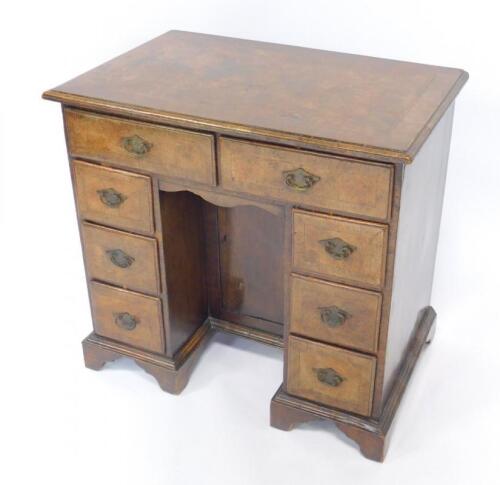 A George II walnut and mahogany cross banded kneehole desk