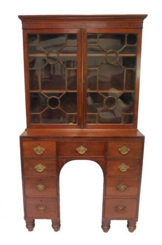 A George III mahogany bookcase on a kneehole desk base
