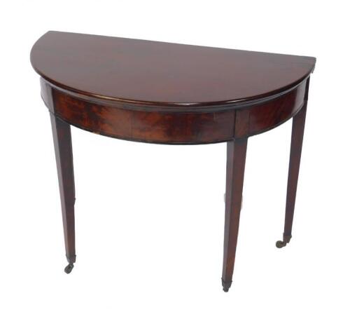 A George IV mahogany demi lune fold over card table